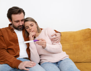Medium shot couple with pregnancy test