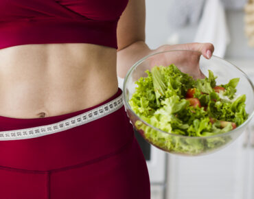 Diet concept with sporty woman in kitchen